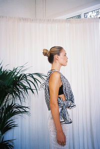 BELLARUCHI one shoulder top sarong side view. BELLARUCHI sarong tied as one shoulder top.  BELLARUCHI Black and White logo Sarong. Black and white logo scarf. Silk Cotton Scarf. B logo Sarong. White and Black Pattern Sarong. Vacation Sarong. Travel Scarf. Travel sarong. 