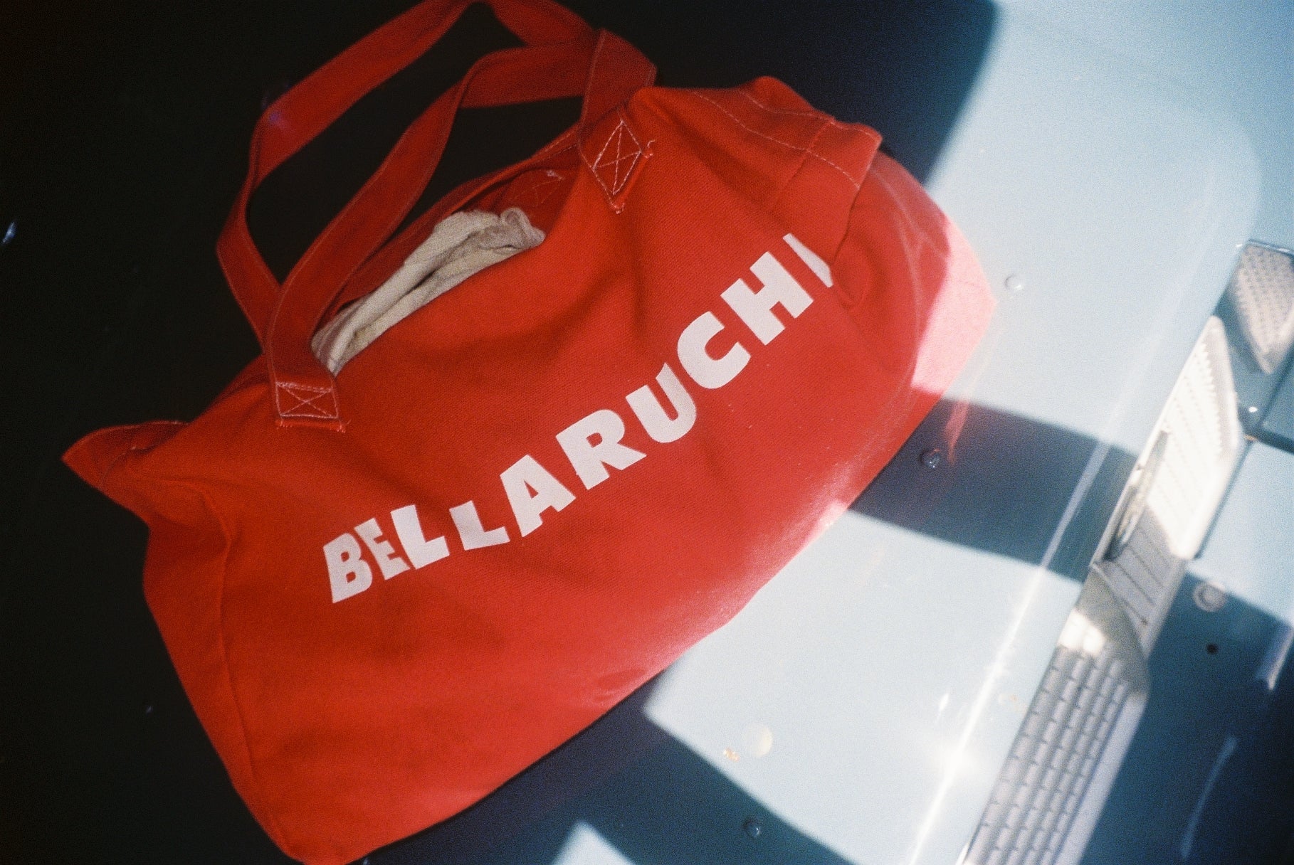travel tote bag 
red bag, white writing 
BELLARUCHI logo